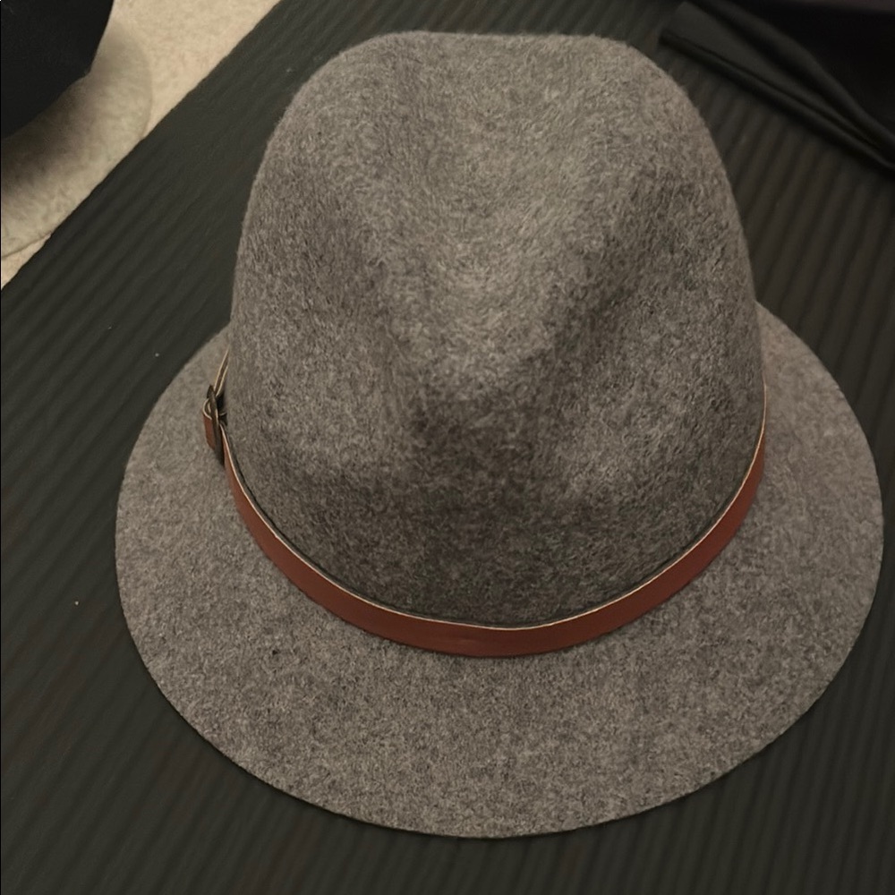 Gray Eugenia Kim fedora style hat with brown trim belt around it